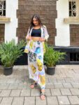 “Woman wearing a trendy multicolor graphic printed co-ord set with face art and celestial motifs, perfect for casual or travel fashion.”