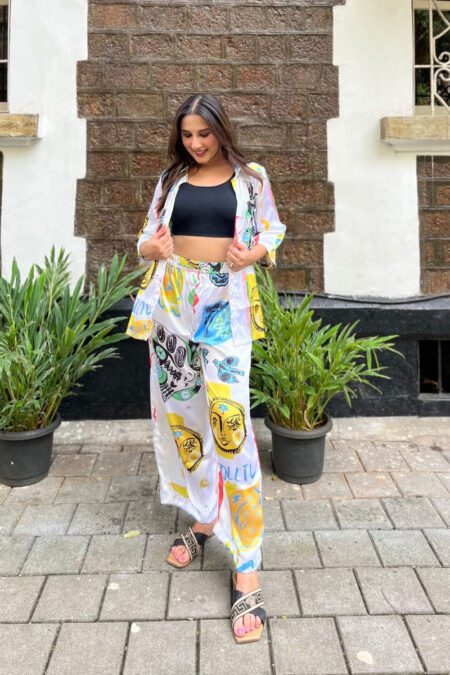 “Woman wearing a trendy multicolor graphic printed co-ord set with face art and celestial motifs, perfect for casual or travel fashion.”