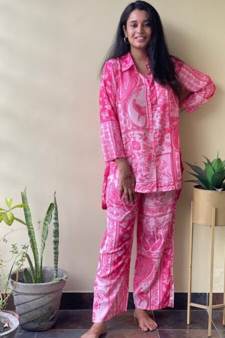 Woman wearing a pink printed cotton co-ord set with floral and paisley design, ideal for loungewear or casual daywear.