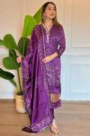 Woman wearing a royal purple Bandhani kurta set with traditional prints and matching dupatta, perfect for festive or ethnic occasions.