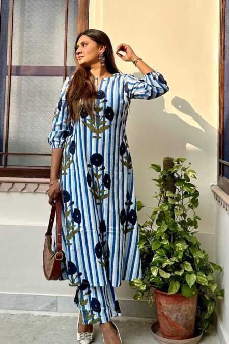 Woman wearing a blue and white vertical striped floral printed kurta set with matching pants.
