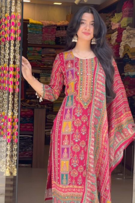 Woman wearing a vibrant red kurta pant and dupatta set with mirror work and traditional temple motifs, perfect for festive occasions.