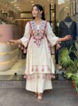 “White designer kurti set with mirror work and tassels, paired with matching palazzo pants for festive ethnic wear.”