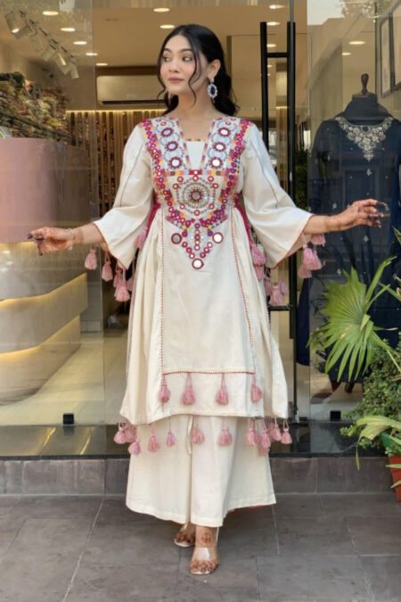 “White designer kurti set with mirror work and tassels, paired with matching palazzo pants for festive ethnic wear.”