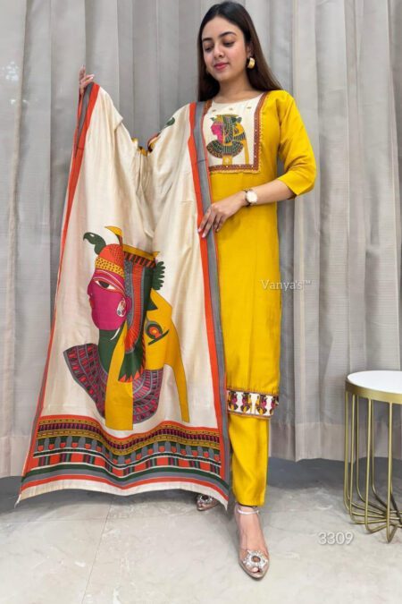 Woman wearing a yellow kurta pant set with an artistic printed silk dupatta, standing against a curtain background in an ethnic outfit perfect for festive or casual wear.