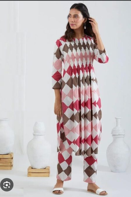 Woman wearing a geometric print cotton kurta and pant set with pleated front design, styled for casual or ethnic occasions.