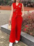 Woman wearing a bright red embroidered sleeveless cotton kurti co-ord set with matching palazzo pants in a garden setting.
