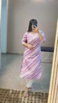 Woman wearing a purple and white striped cotton kurti with white pants, posing indoors for stylish ethnic daily wear.
