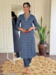 Woman wearing an indigo blue striped cotton kurti with embroidered neckline, 3/4th sleeves, and straight-fit design, standing indoors with a mirror and plant in the background.
