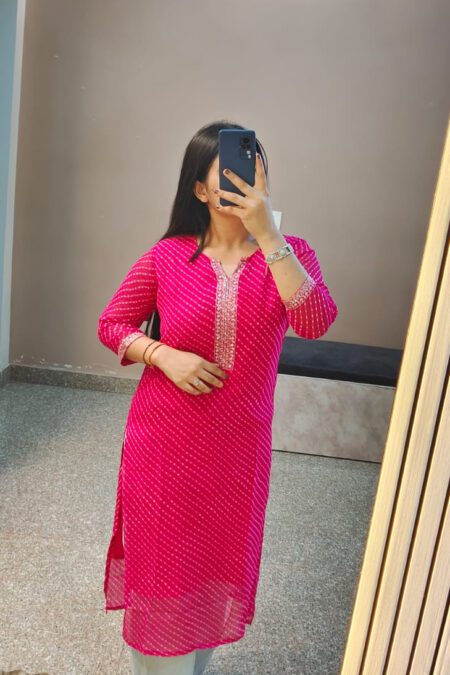 Woman wearing a magenta Bandhani cotton kurti with embroidered neckline, styled for daily ethnic wear.