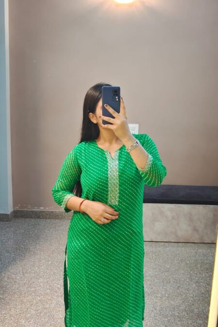Woman wearing green Bandhani cotton kurti with embroidered neckline, styled for ethnic daily wear or festive occasions.