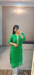 Woman wearing green Bandhani cotton kurti with embroidered neckline, styled for ethnic daily wear or festive occasions.
