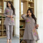 Model wearing taupe embroidered cotton co-ord set featuring floral button-down shirt and matching straight pants, ideal for office or casual wear.